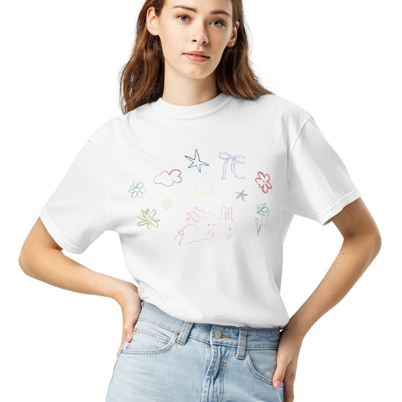 Person wearing a white t-shirt with spring inspired doodles and light blue jeans on a white background
