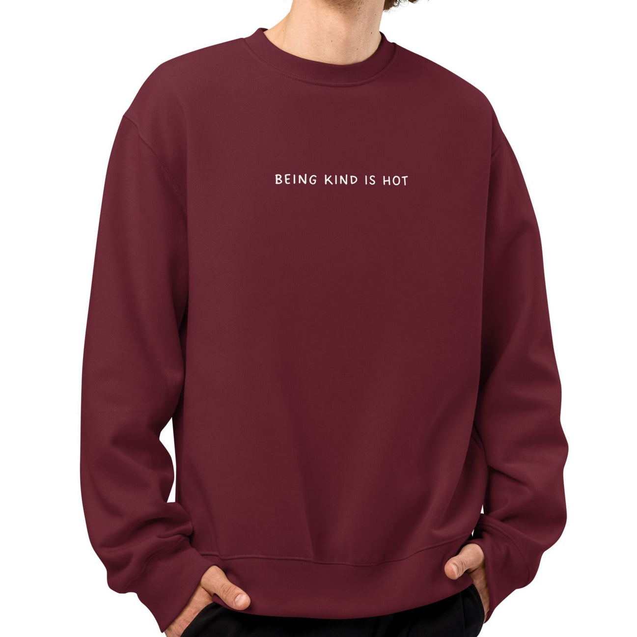 Man wearing a maroon sweatshirt with 'BEING KIND IS NOT' text on a white background